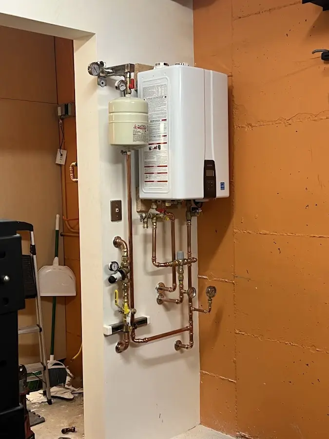 Plumbing technician inspecting water heater connections in Brookshire
